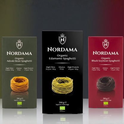 Nordama organic gluten-free spaghetti trio featuring edamame, adzuki bean, and black soybean pasta boxes on a premium dark gradient background.